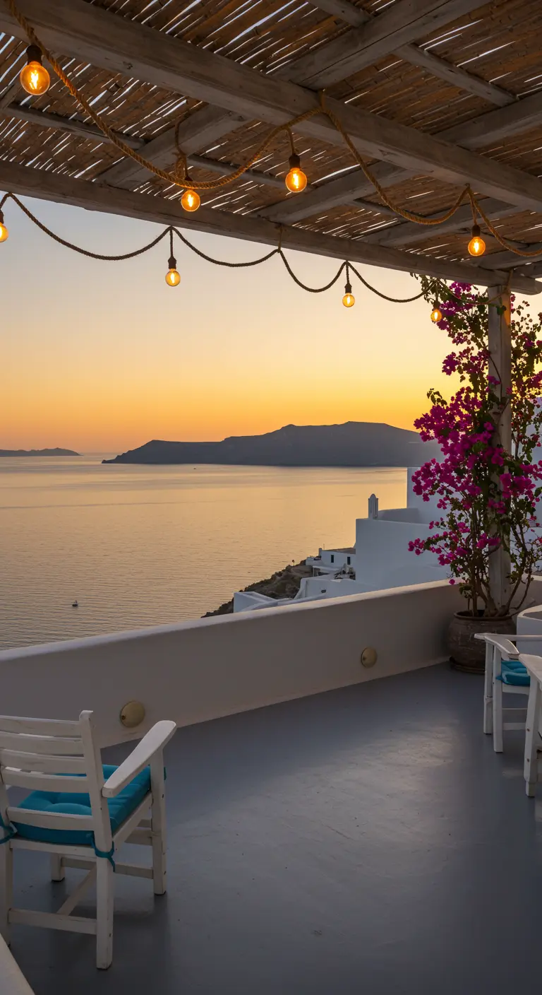 Terrace with white chairs overlooking the sea at sunset, with rope lights and bougainvillea.
