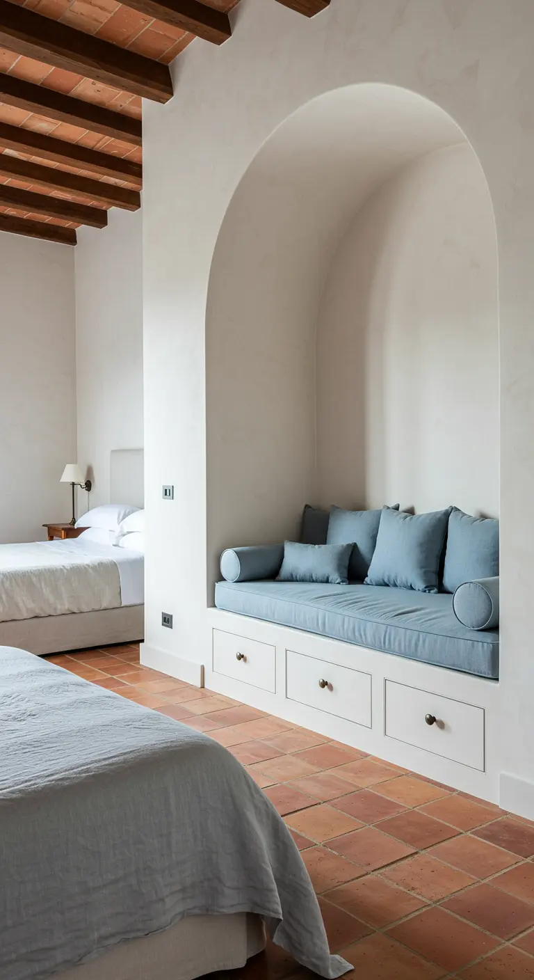 A built-in reading nook with blue cushions and storage, set within a white archway.