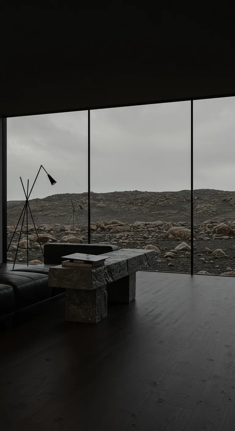 A moody living room with a chunky, brutalist concrete coffee table and a view of a rocky landscape.