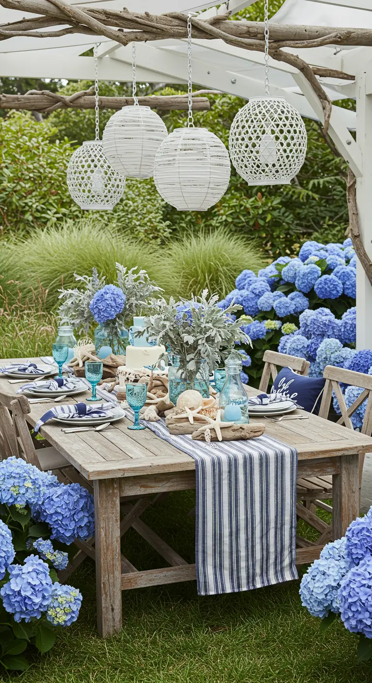 Coastal-themed table surrounded by hydrangeas with white rattan lanterns overhead.