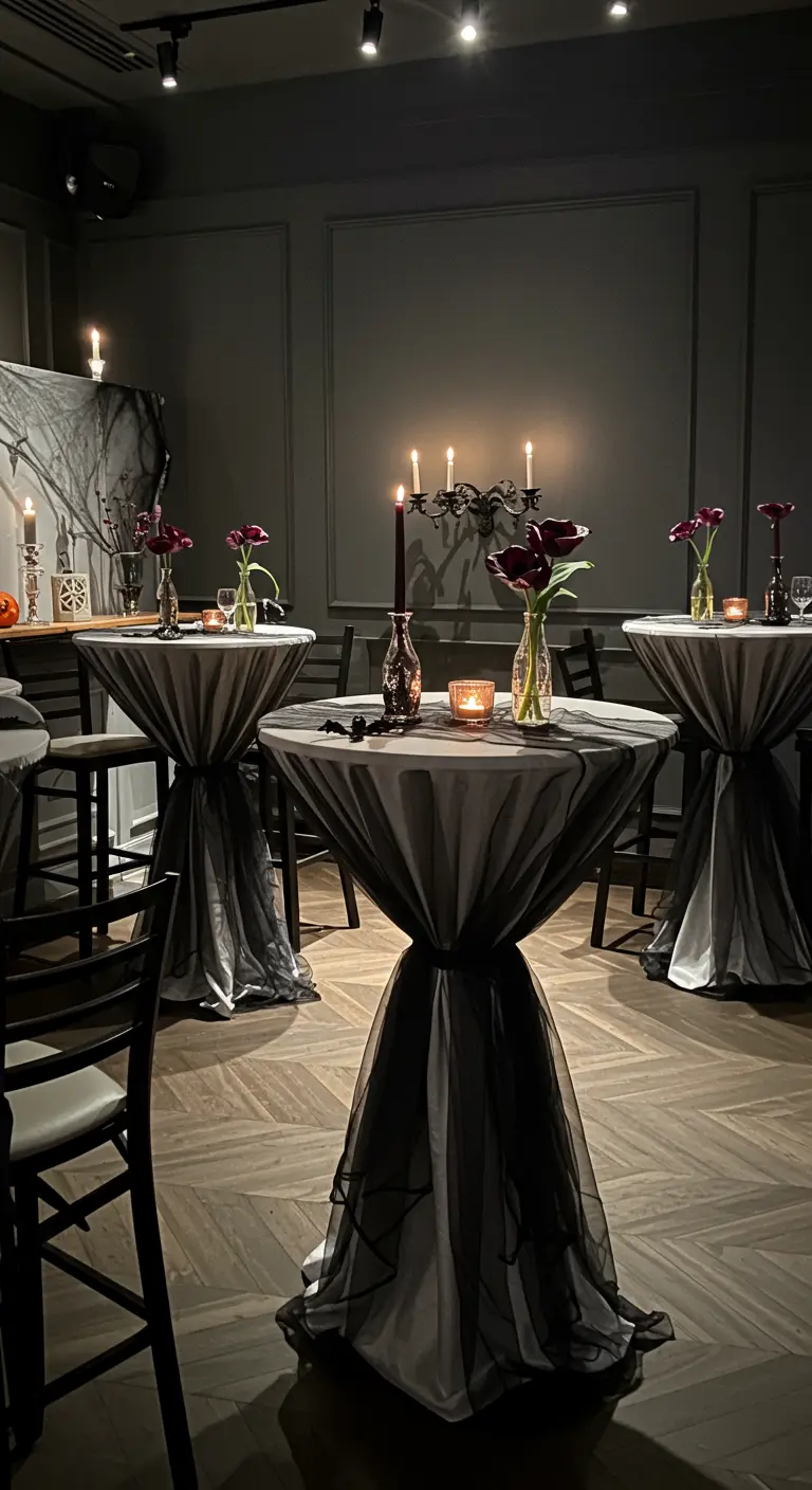 High-top cocktail tables draped in grey and sheer black fabric to look like ghostly figures.
