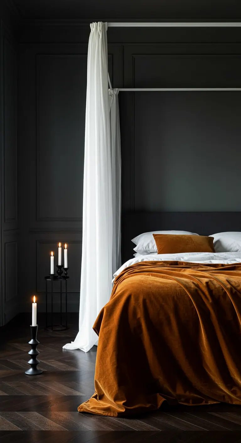 Modern dark bedroom with a single white drape and a golden velvet throw.