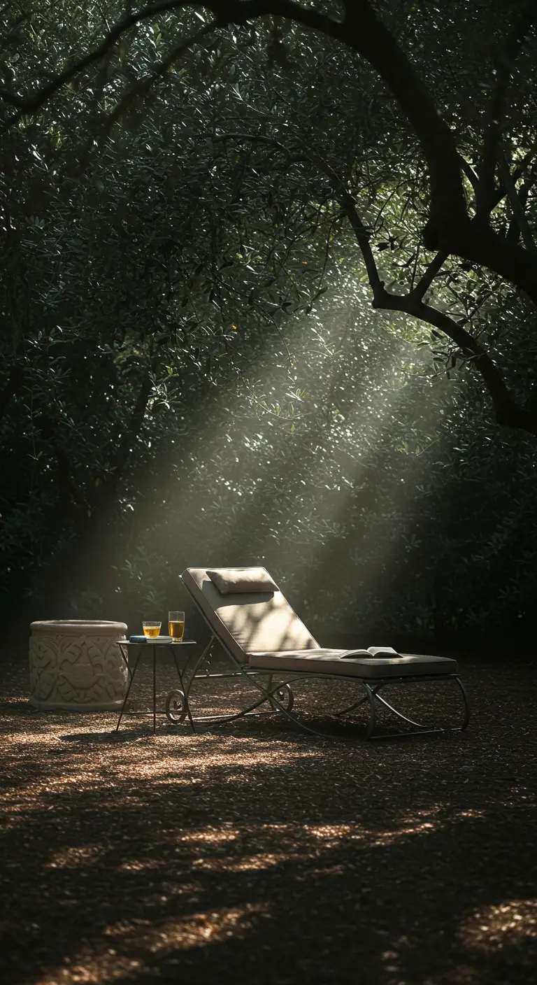 A single lounger and a stone basin illuminated by a dramatic ray of sunlight in a grove.