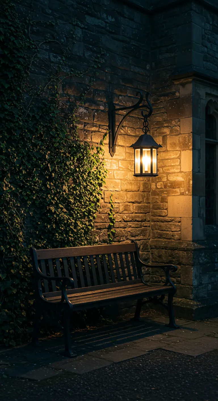 A single, warm lantern illuminates a dark wooden bench against a stone wall at night.